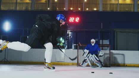 Professioneller-Eishockeyspieler-Und-Torwart-Trainieren-Das-Schlagen-Des-Pucks-Auf-Das-Tor.-Torwart-Und-Spieler-Im-Training.-Zeitlupe
